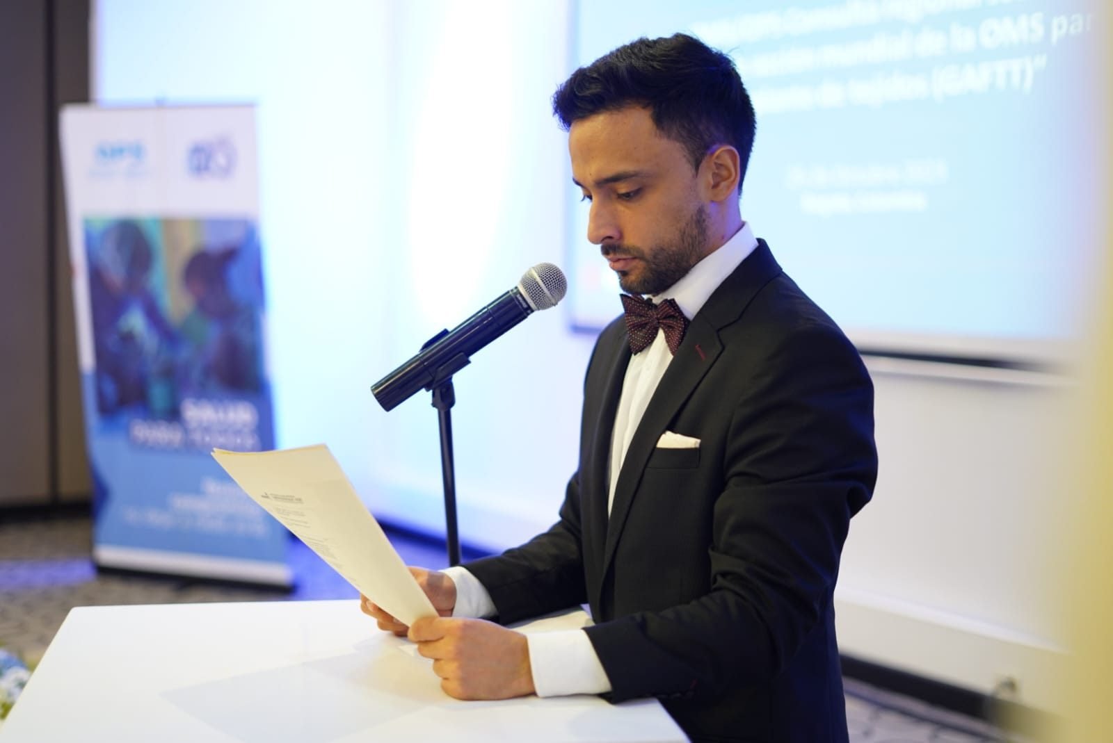 Dani como presentador en un evento, leyendo frente al micrófono